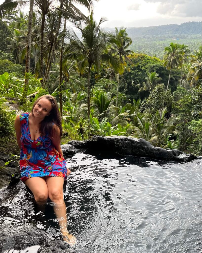 Ellis in a pool waterfall in Sidemen with a forest view