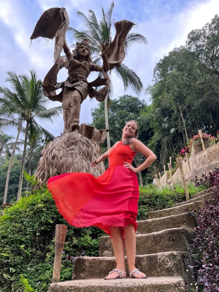 traveler with red dress infront of a statue in Tegallalang Ubud