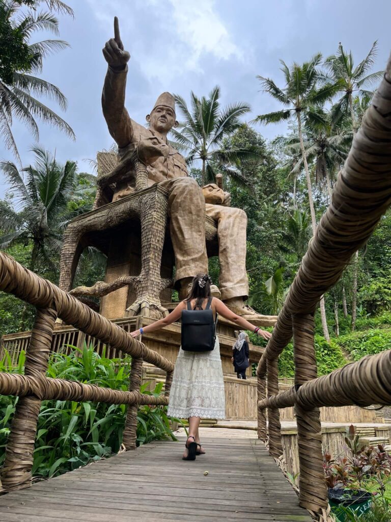 Traveler standing in front of a massive statue at Tegallalang Rice Terraces in Ubud, Bali