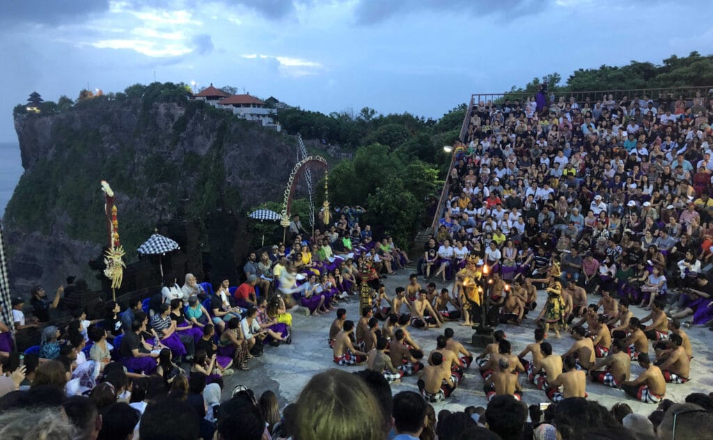 Crowd watching the Kecak Fire Dance at Uluwatu Temple cliffside amphitheater in Bali